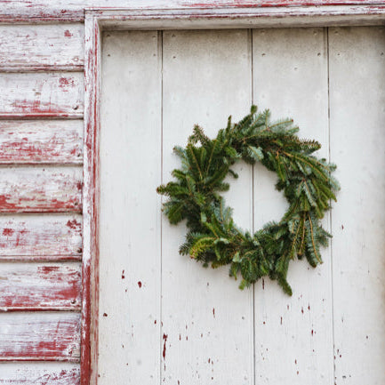 Rustic front porch decorated with artificial greenery