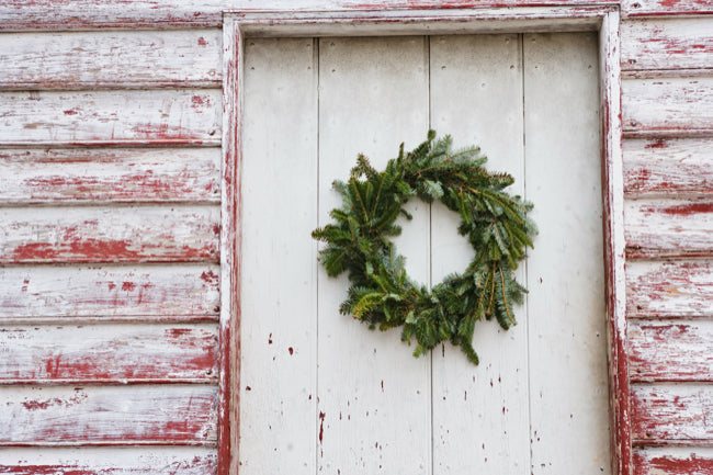 Rustic front porch decorated with artificial greenery