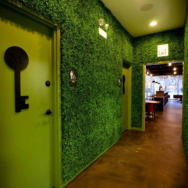 Dense artificial foliage covering the walls of an indoor corridor